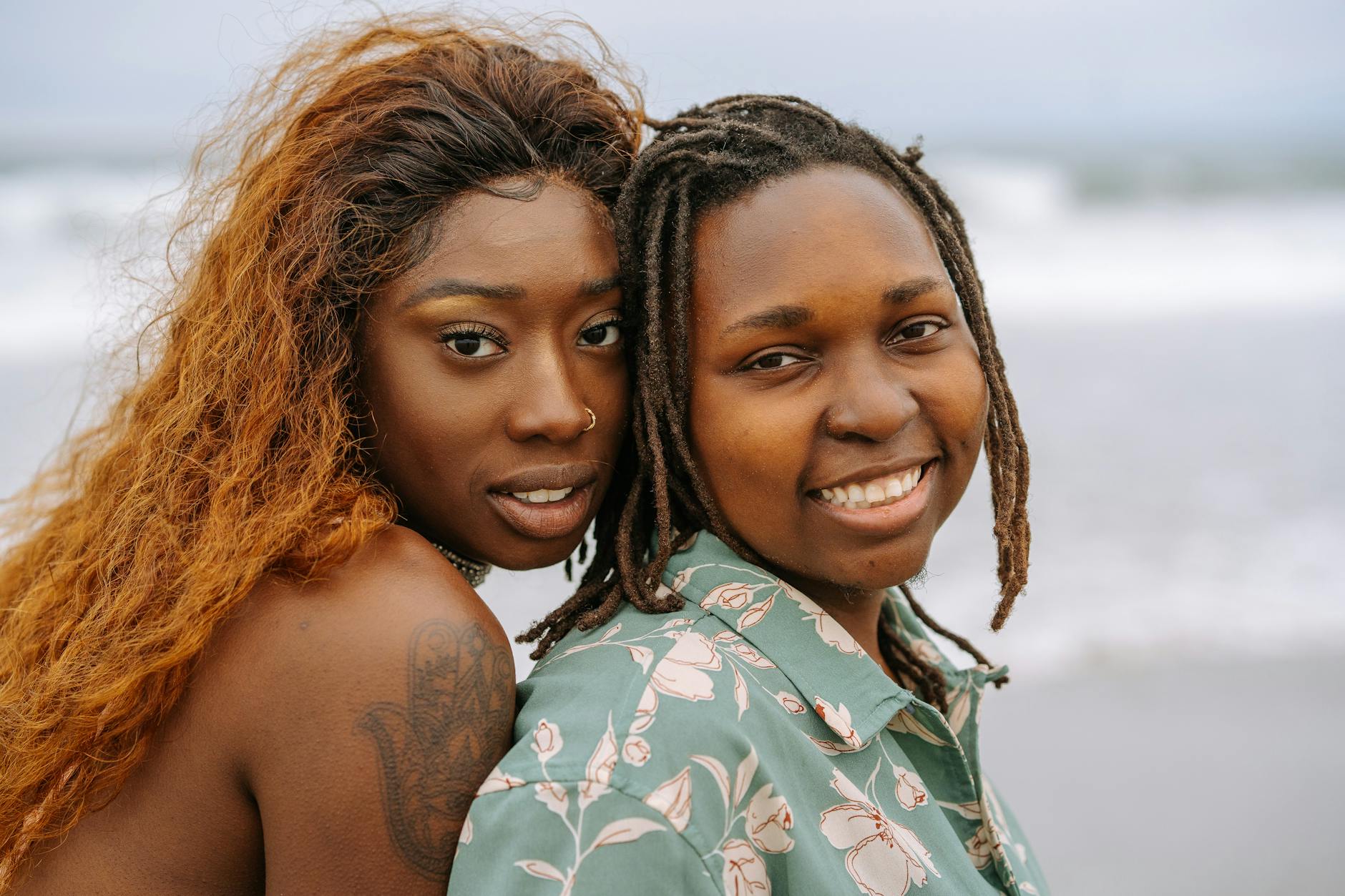 Czarna lesbijka przytulająca partnerkę na wietrznej plaży na Sardynii