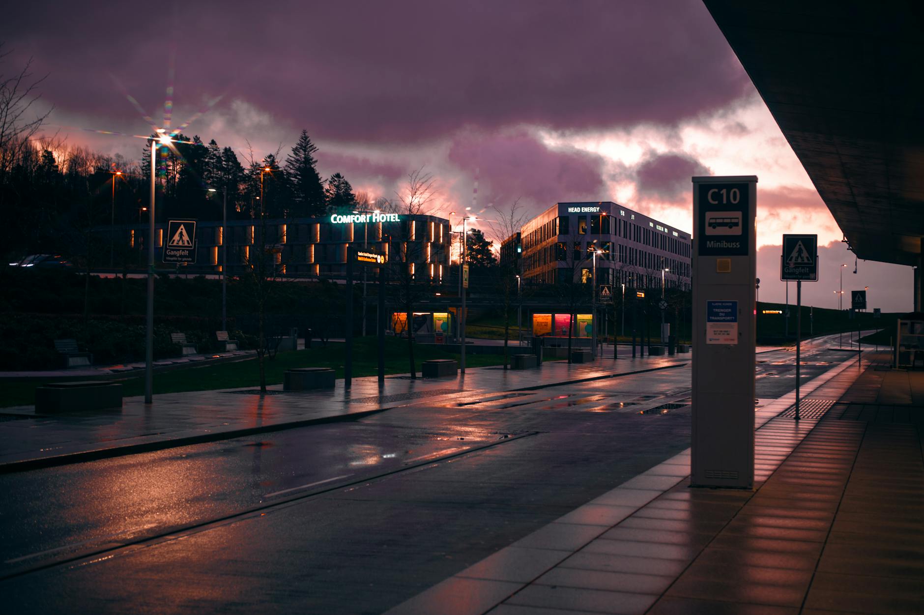 Nocna ulica w dużym mieście z hotelem Comfort Hotel i mokrym asfaltem