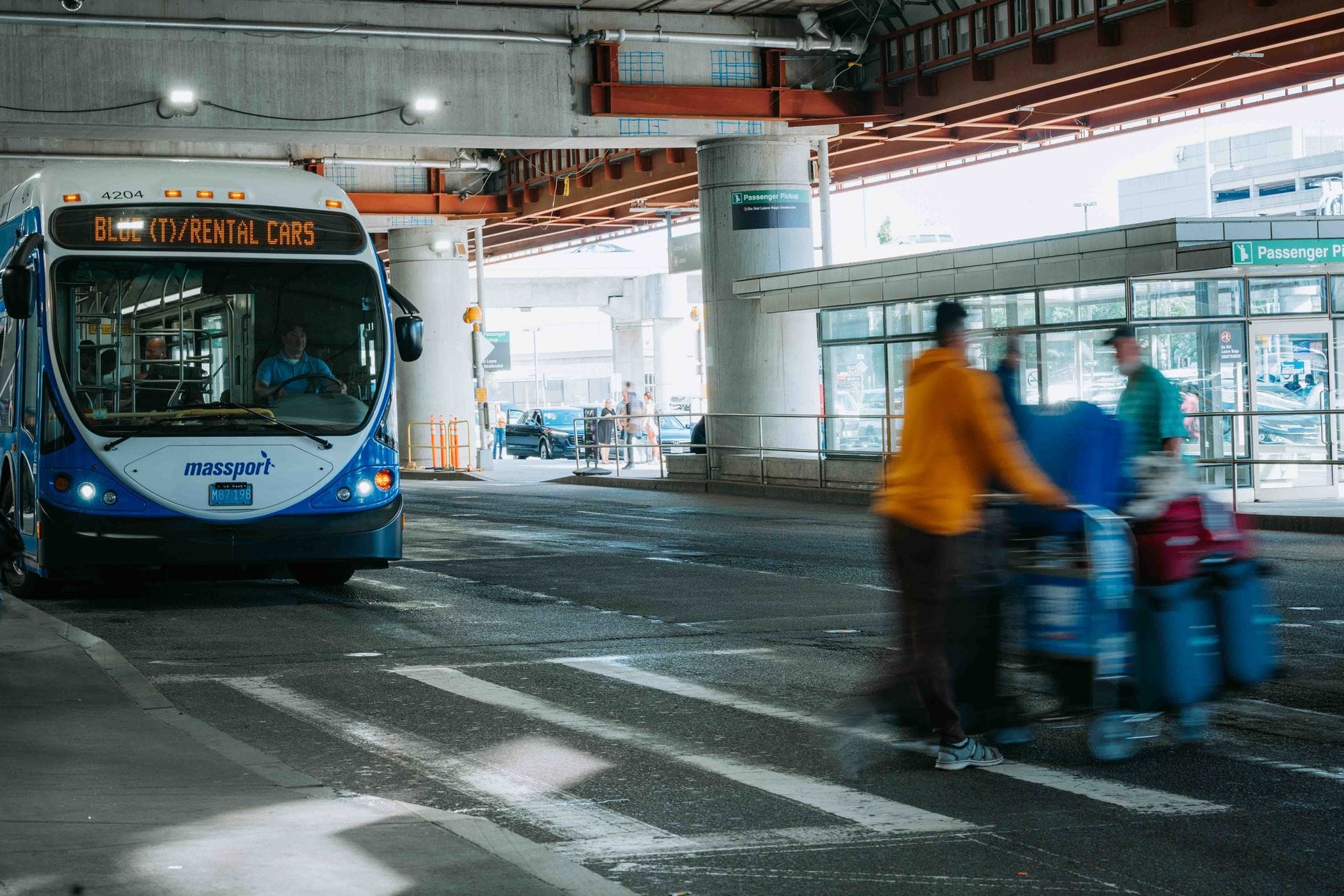 Podróżni na ruchliwym lotnisku obok autobusu wypożyczalni aut Podróżni na ruchliwym lotnisku obok autobusu wypożyczalni aut