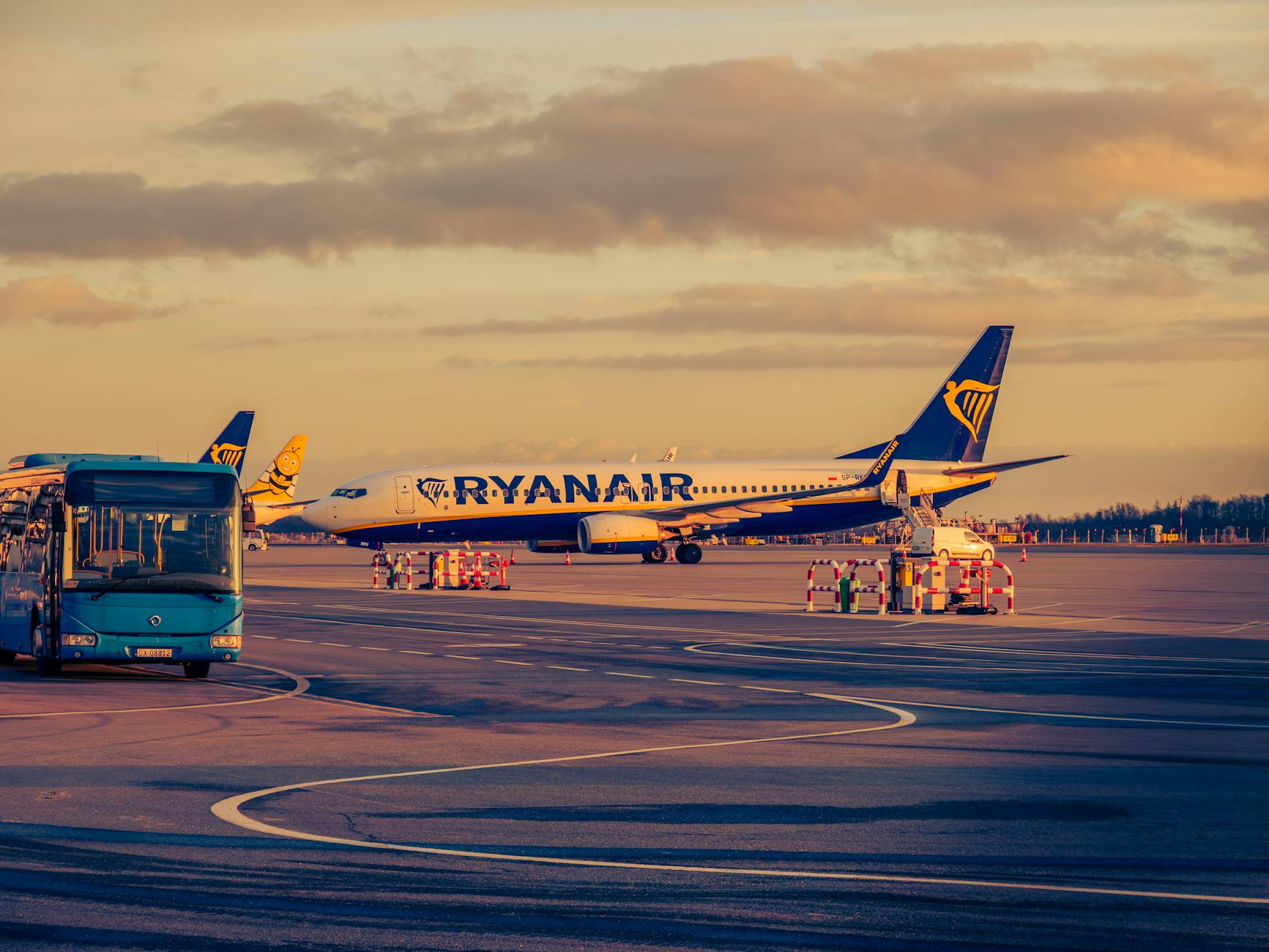 Samolot Ryanair i autobus transferowy na lotnisku we Wrocławiu o zachodzie słońc
