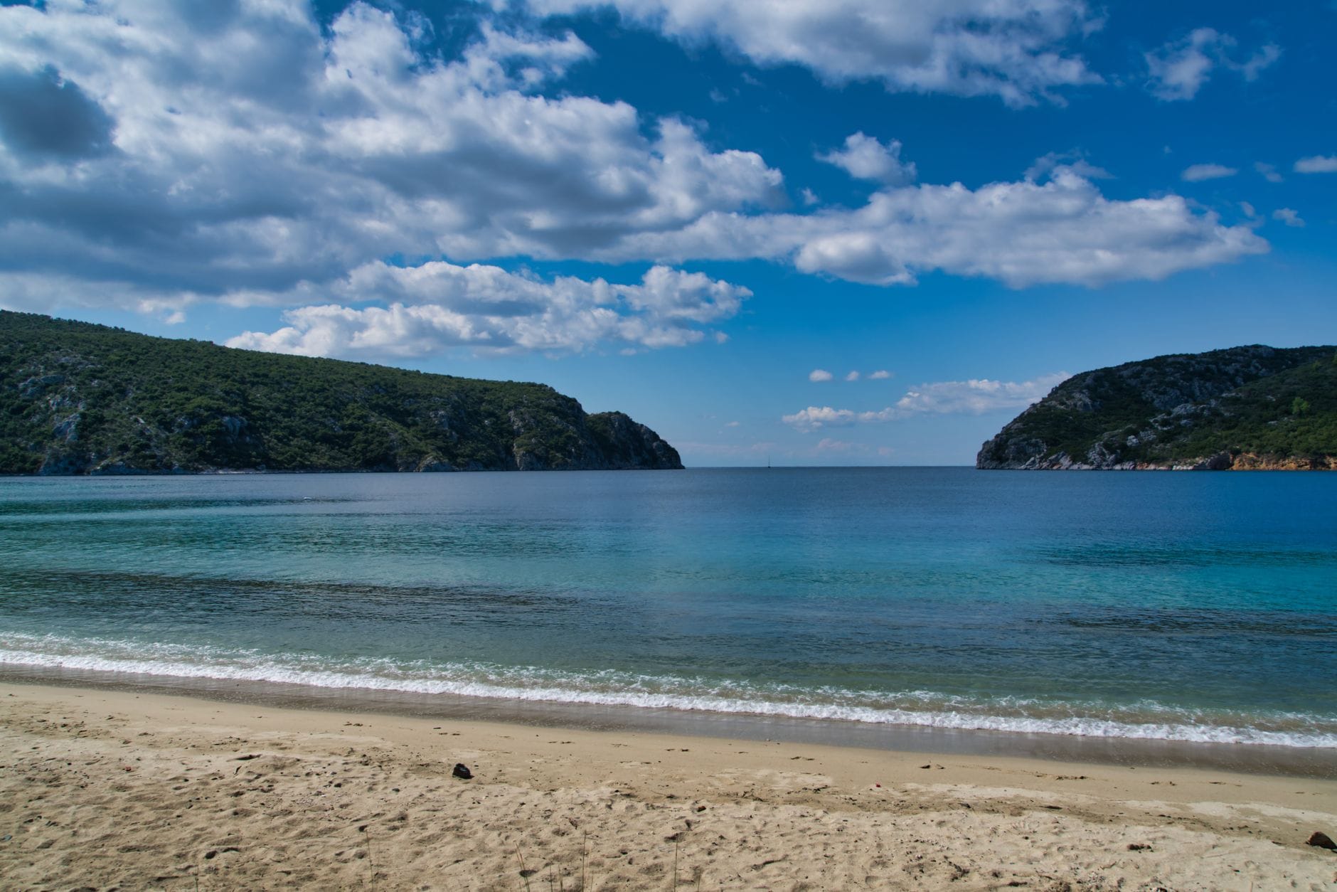 Spokojna grecka plaża z turkusowym morzem i pustym piaszczystym brzegiem