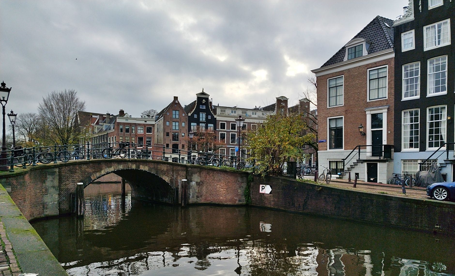 Most nad kanałem w Amsterdamie i rząd tradycyjnych kamienic pod chmurami