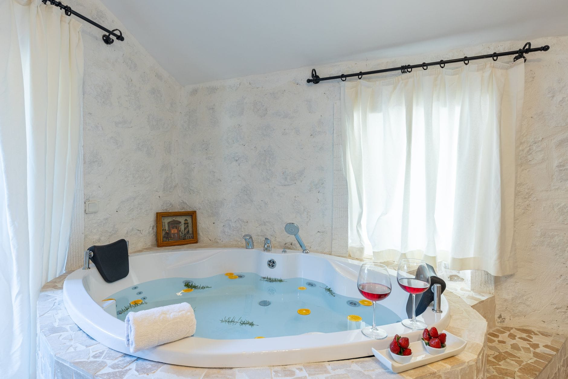 Para relaksuje się w luksusowym jacuzzi z winem i truskawkami